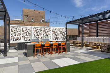 A patio with grassy area and orange chairs.