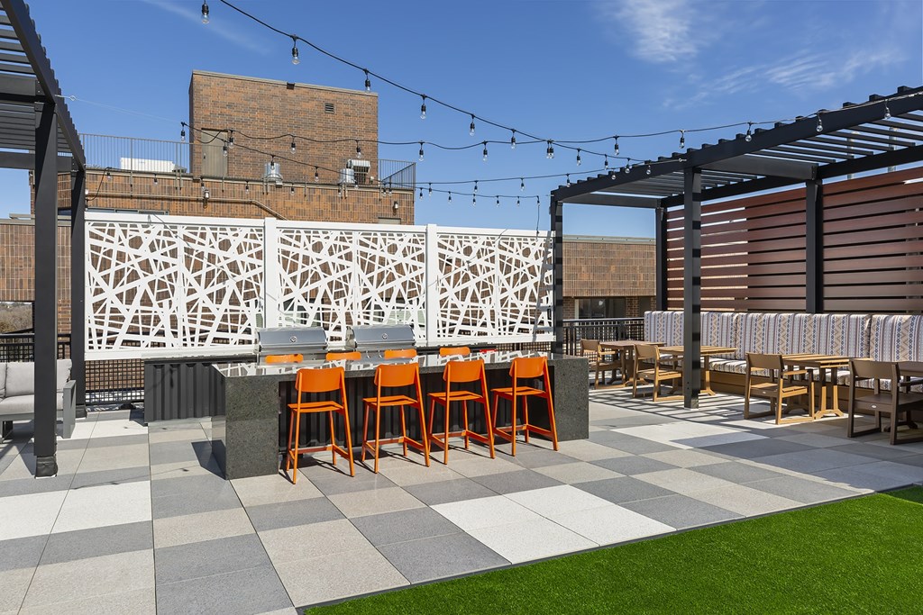 A patio with grassy area and orange chairs.