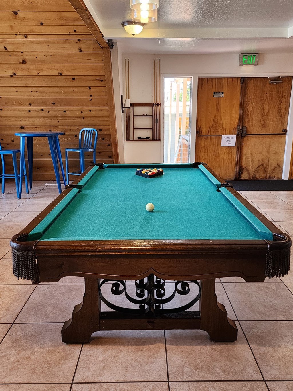 A pool table with a green cloth and a white ball in the middle. at Salinas Sunset Apartments, Salinas, CA