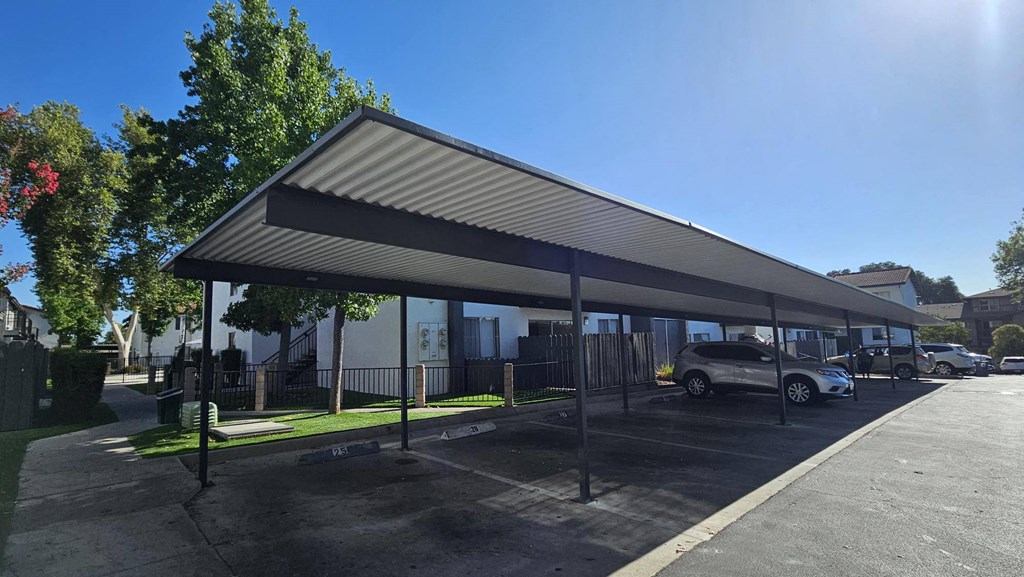 a covered parking lot with cars parked under a canopy at Alturas Paso Robles Apartment Homes, Paso Robles, California