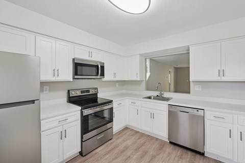 A kitchen with white cabinets and stainless steel appliances.