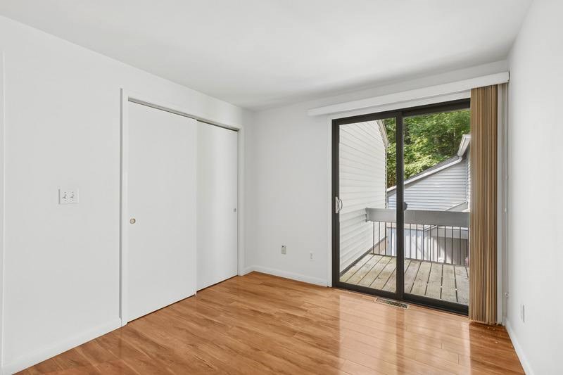 A room with a sliding glass door leading to a balcony.