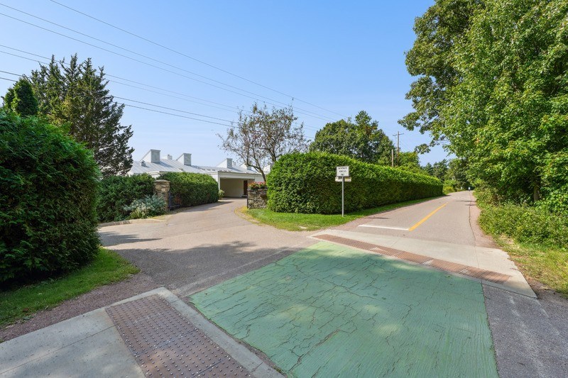 A green painted area on a bike path and road with a white sign in the background.