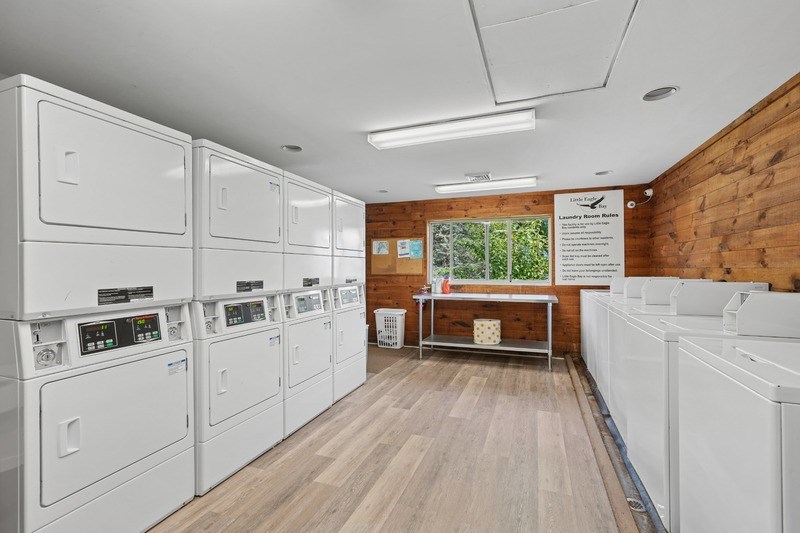 A laundry room with washers and dryers on both sides of the room.