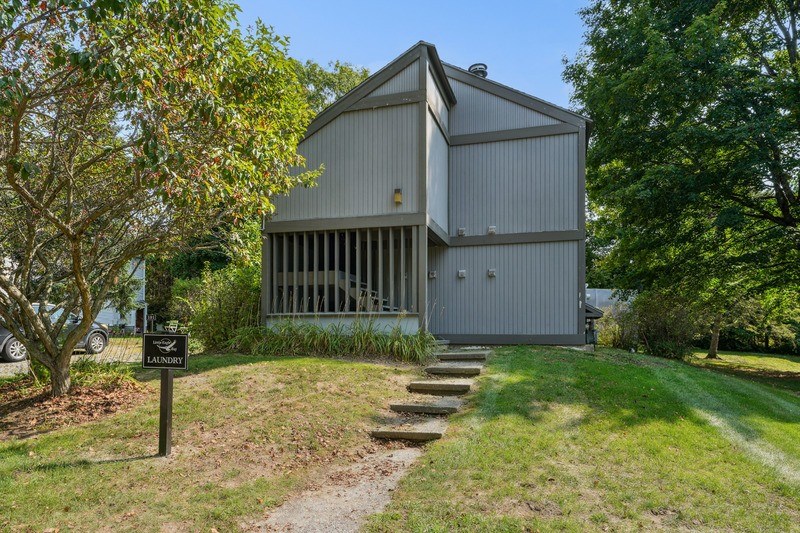 A laundry facility is located in a grassy area next to a building.