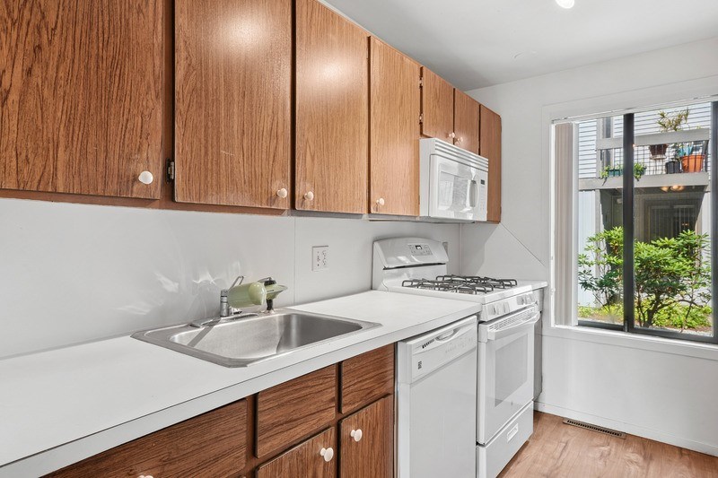 A kitchen with wooden cabinets and white appliances.