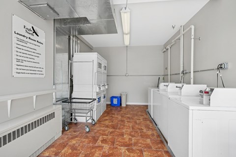 A laundry room with a sign on the wall and a basket in the middle.