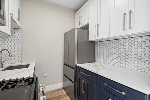 A kitchen with a black stove top oven and a black refrigerator.