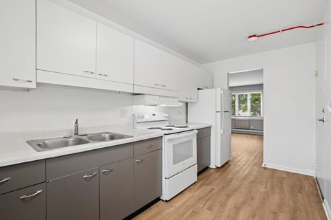 A kitchen with white cabinets and a window.