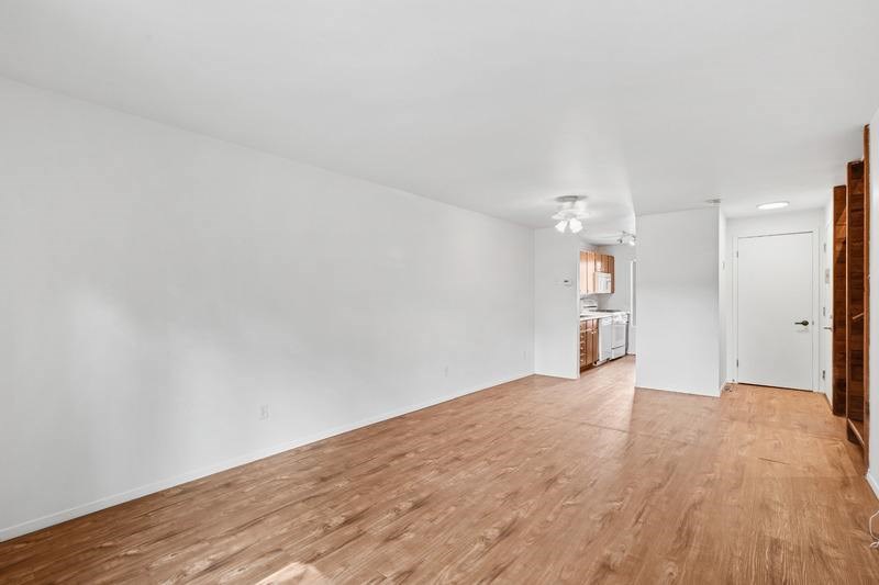 A room with wooden flooring and white walls.