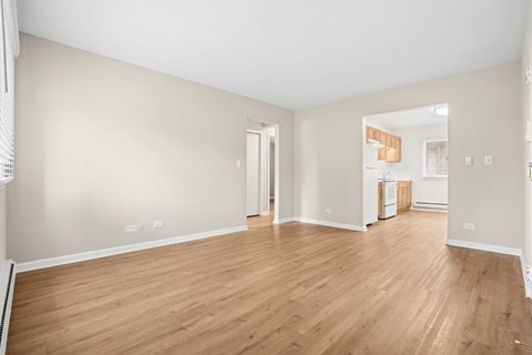A large empty room with wooden floors and white walls.