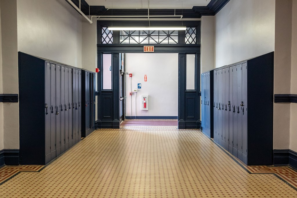 a hallway with rows of lockers and doors in a building at Residences at South High, Pittsburgh, 15203 ?