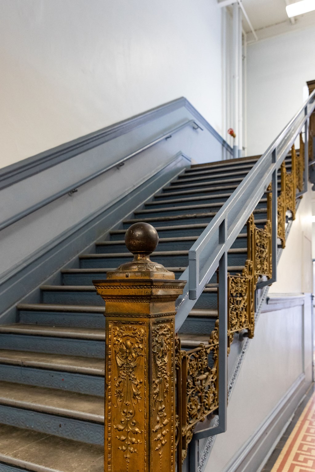 a set of stairs with a metal railing and a gold column in front of them at Residences at South High, Pittsburgh, PA ?