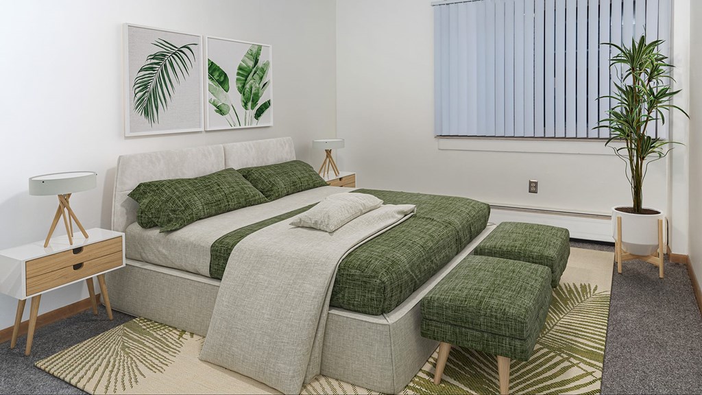 A bedroom with a large bed and a green blanket.