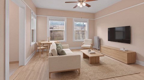 A living room with a beige sofa, a wooden coffee table, and a flat-screen TV mounted on the wall.