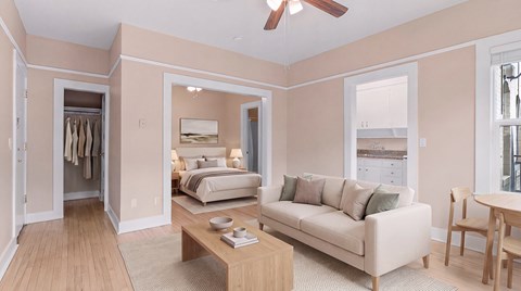 A bedroom with a bed, a couch, and a table.