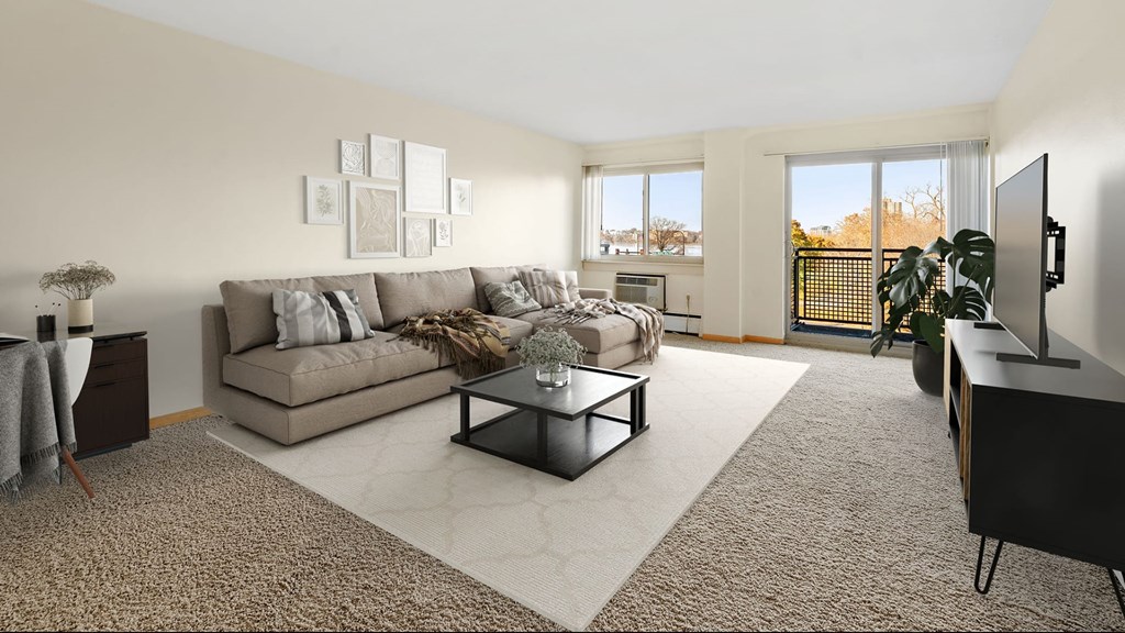 A living room with a grey couch, a coffee table, and a flat screen TV.