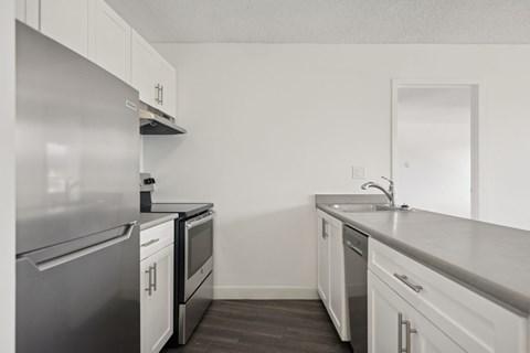 A kitchen with white cabinets and stainless steel appliances.