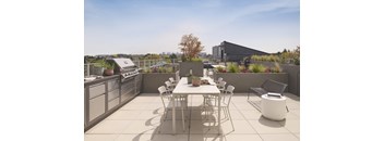 A patio with a table and chairs overlooking a cityscape.