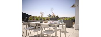 A white table and chairs are set up on a patio.