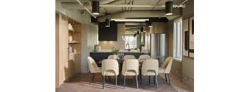 A modern dining room with a long table and chairs.