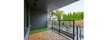 A balcony with a brick floor and a metal railing.
