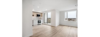 A modern kitchen with wooden floors and white walls.