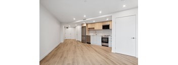 A kitchen with white cabinets and a wooden floor.