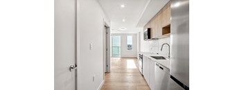 A modern kitchen with white appliances and wooden cabinets.