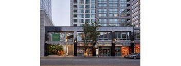 A modern building with a glass facade and a sign that reads