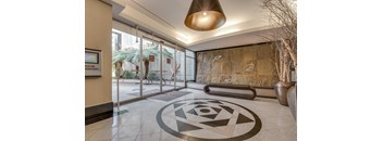 Carmana's entrance with art on the floor leading to a glass door