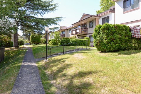 A pathway leads through a grassy area in front of a building.