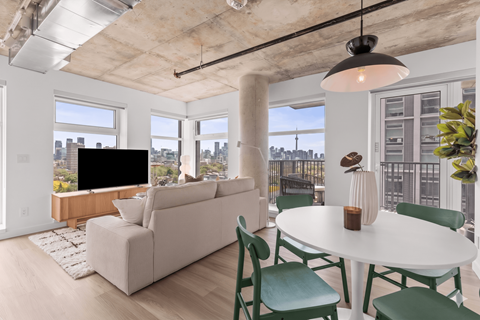A living room with a white couch and green chairs.