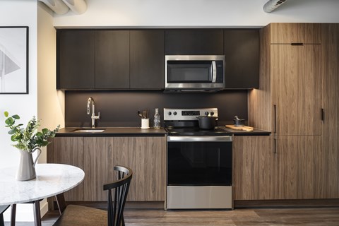 A modern kitchen with dark brown cabinets and a white countertop.