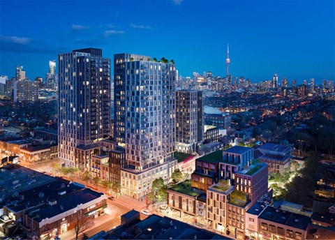 A cityscape at dusk with a prominent building featuring a green roof.