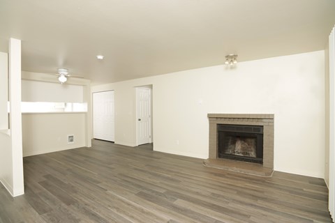 A living room with a fireplace and wood flooring.