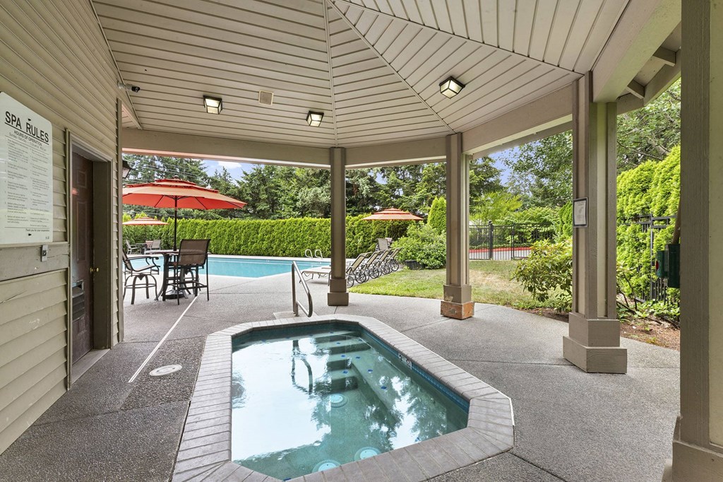 A pool area with a hot tub and a sign that says "SEA RULES".