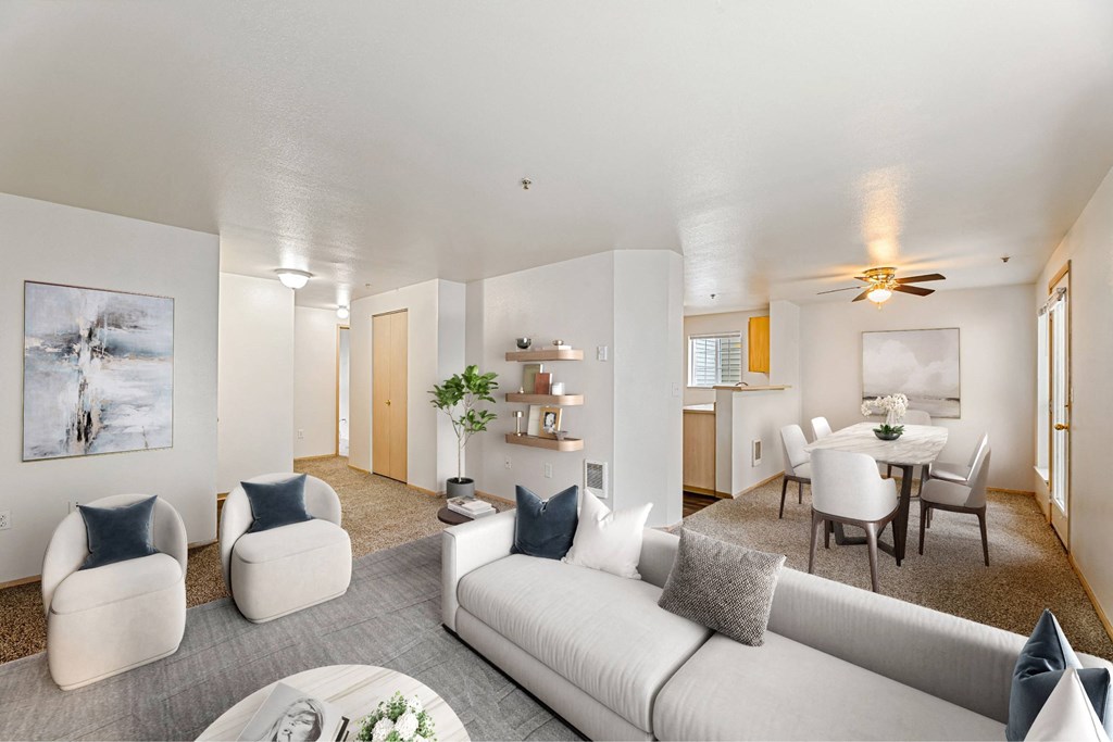 A living room with a white couch and grey pillows.