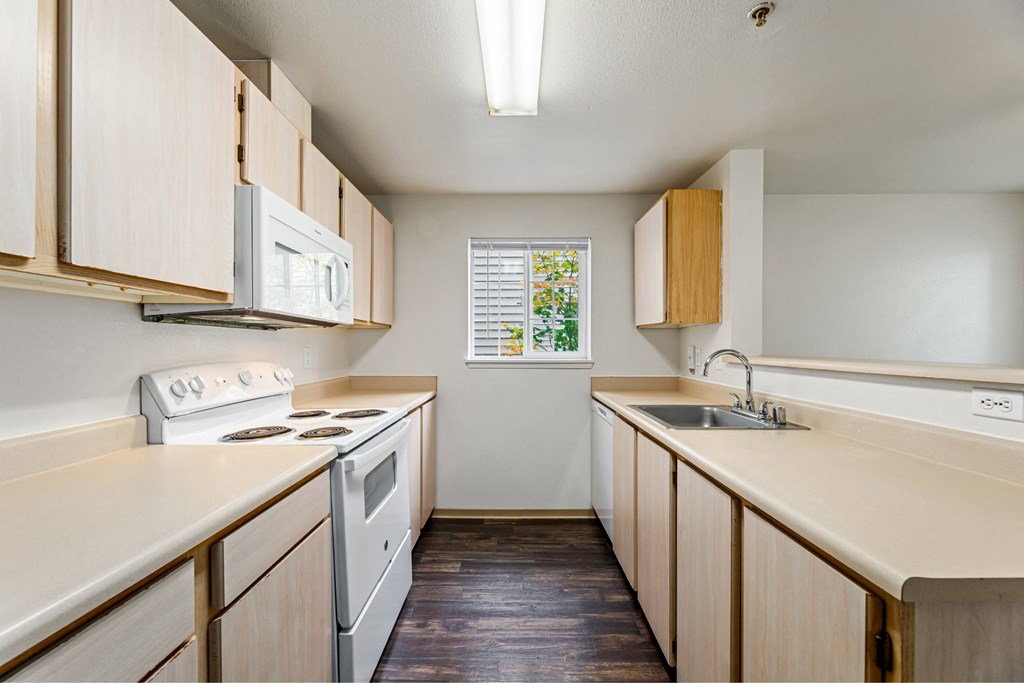 A kitchen with wooden cabinets and a white stove top oven.