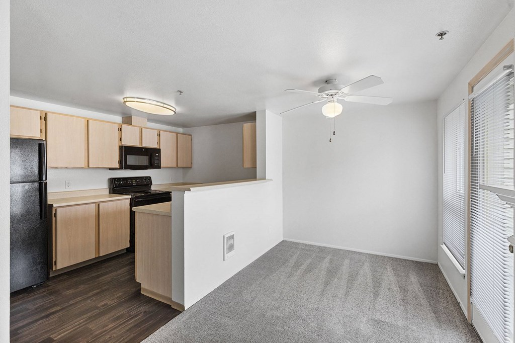 A kitchen with wooden cabinets and a black refrigerator.