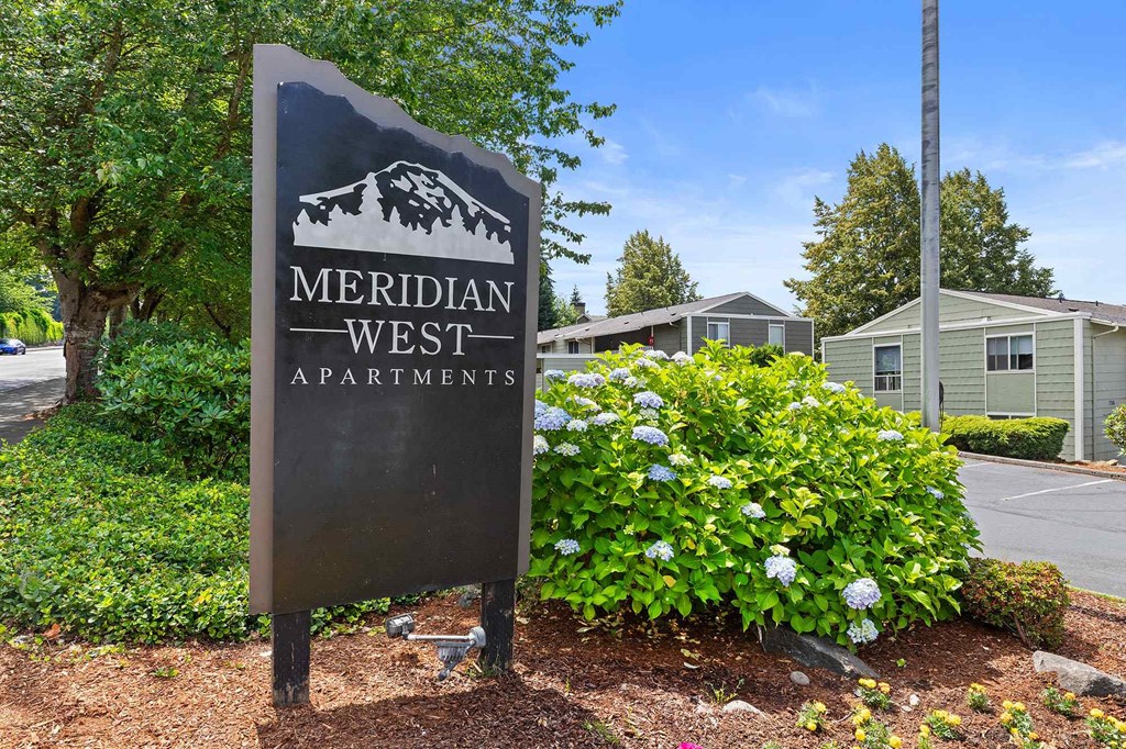 A sign for Meridian West Apartments is shown in front of a building.