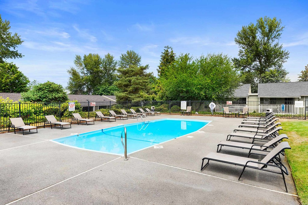A large outdoor swimming pool surrounded by sun loungers.