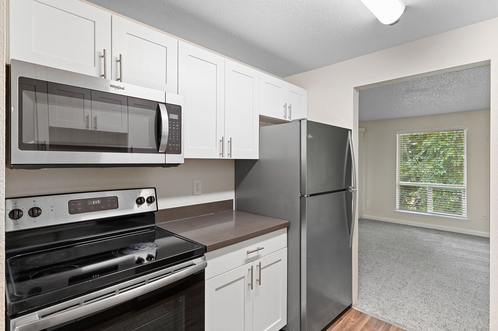 A kitchen with white cabinets and stainless steel appliances.