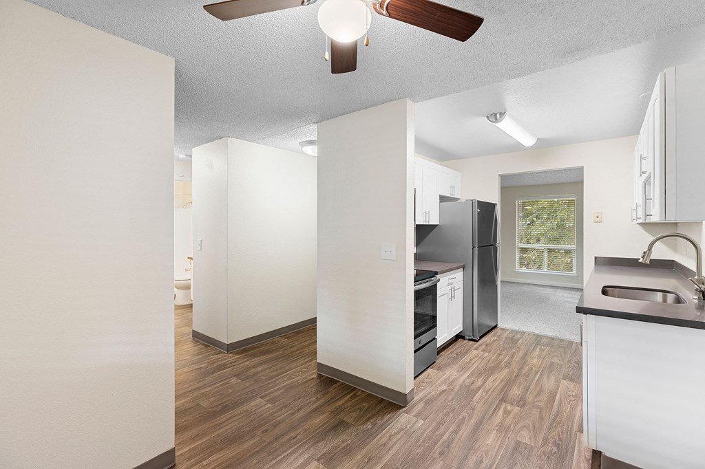 A kitchen with a refrigerator, sink, and oven.