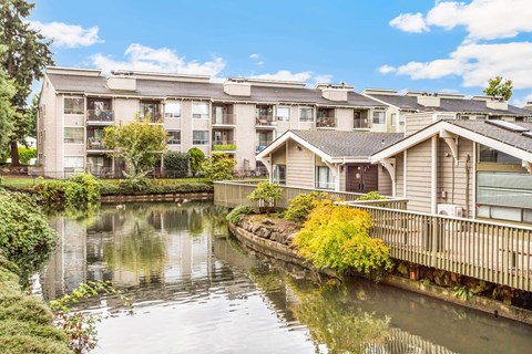 A row of houses with a body of water in front.