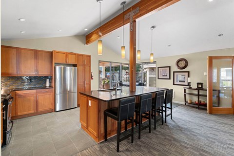 A kitchen with wooden cabinets and a large island with chairs.