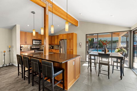 A kitchen with a long island and chairs.
