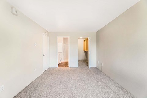 A spacious room with carpeted floor and white walls.