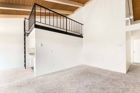 A white room with a black railing on the stairs.
