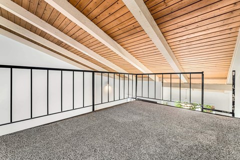 A room with a wooden ceiling and a carpeted floor.